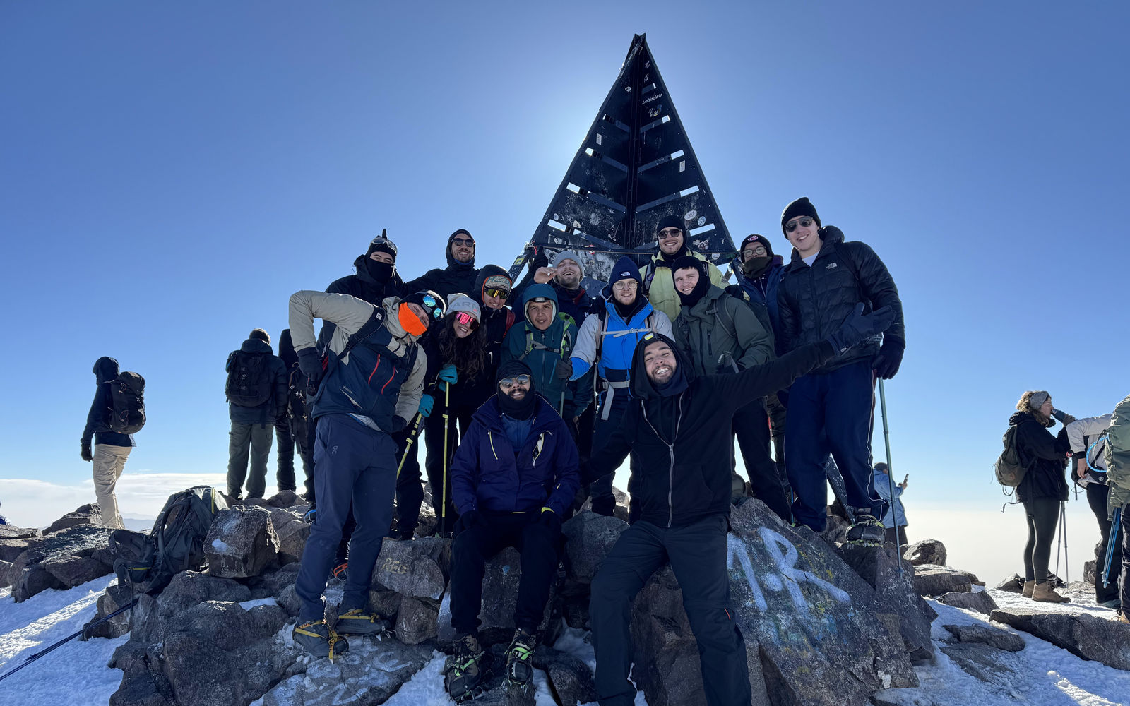 Mahmoud and a group of travellers at a snowy mountain summit